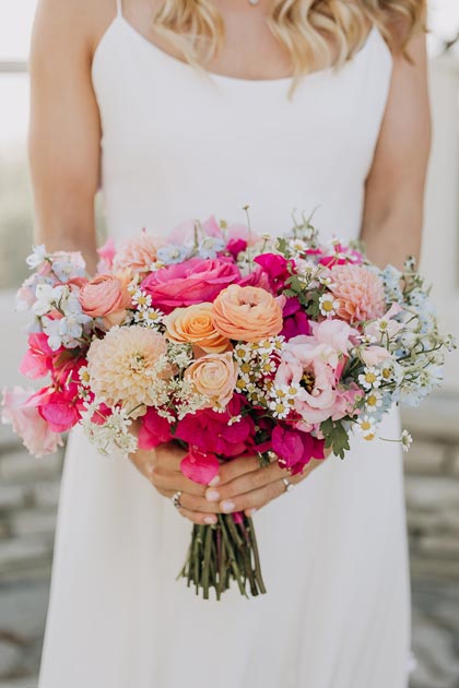 Bridal bouquet with dahlias, roses, and bright pink blooms