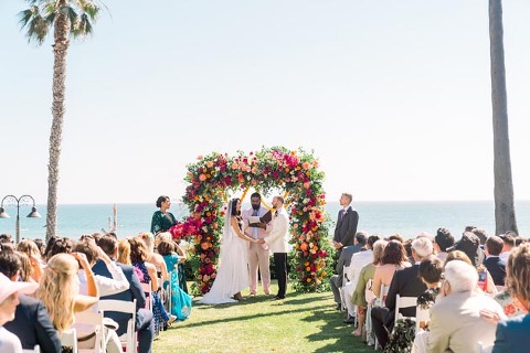 Bride and groom exchanging vows at a California seaside wedding